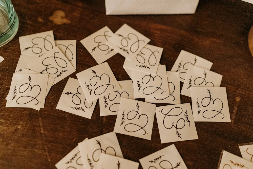 White cards with an art that combines the couple's initials.