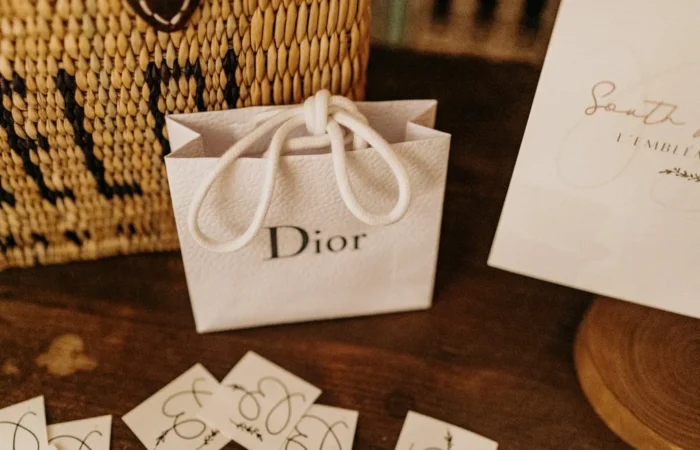 White textured Dior bag on top of a wood table.