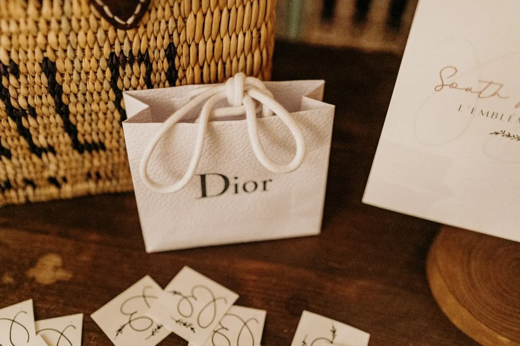 White textured Dior bag on top of a wood table.