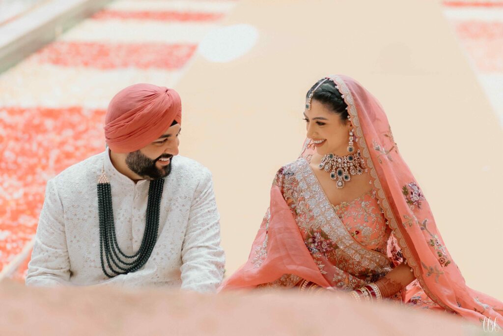 A couple laughing joyfully during their Sikh wedding celebration